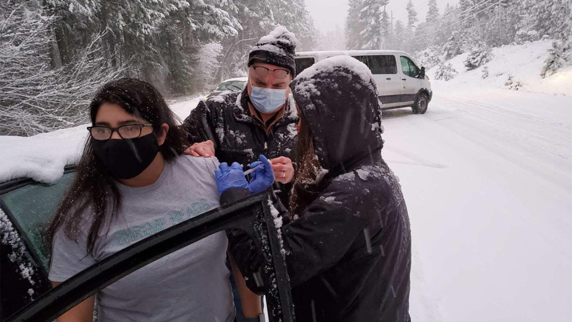 Health workers stuck in snow give other drivers COVID-19 vaccine