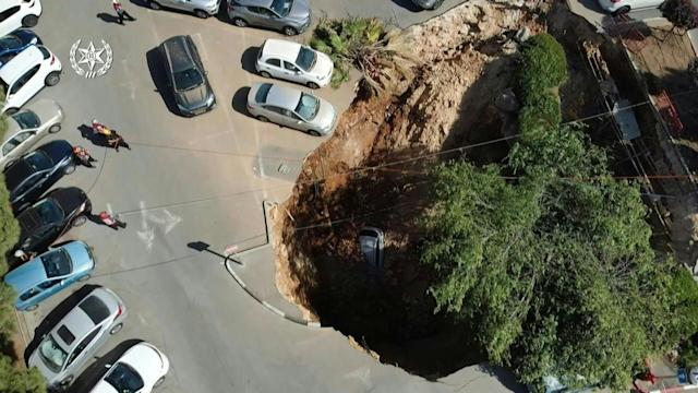 Sinkhole suddenly swallows up parked cars