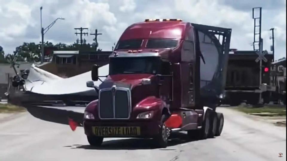 Semi-truck splits when hit by train at railroad crossing gate