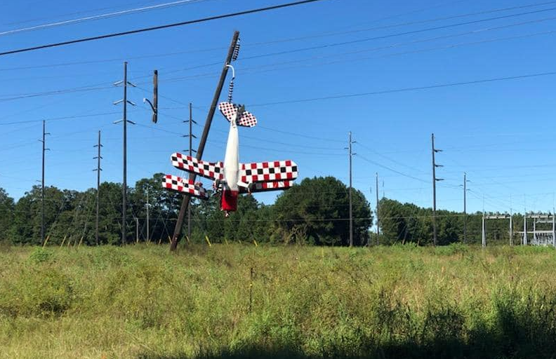 Pilot dangling when plane caught in power lines