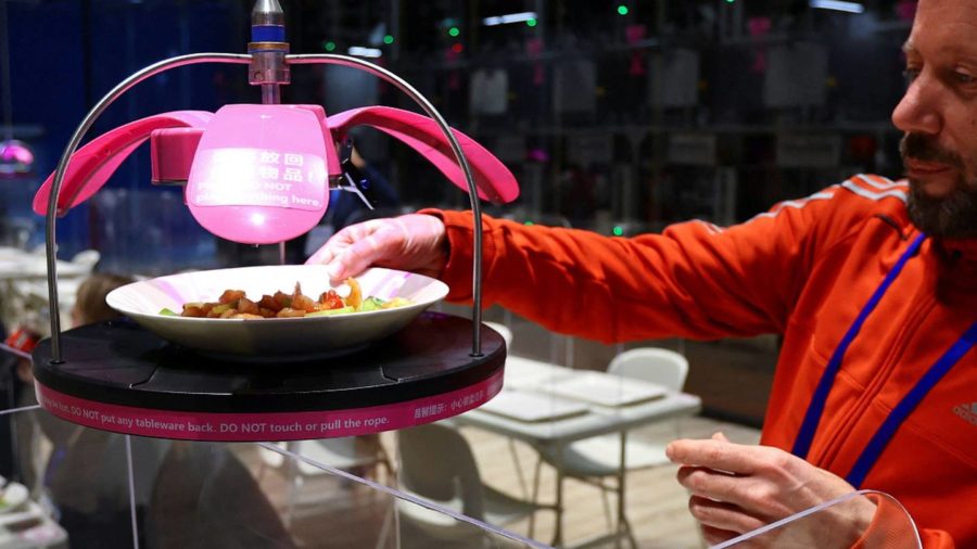 Robot waiters deliver dishes in unusual way at the Beijing Olympics